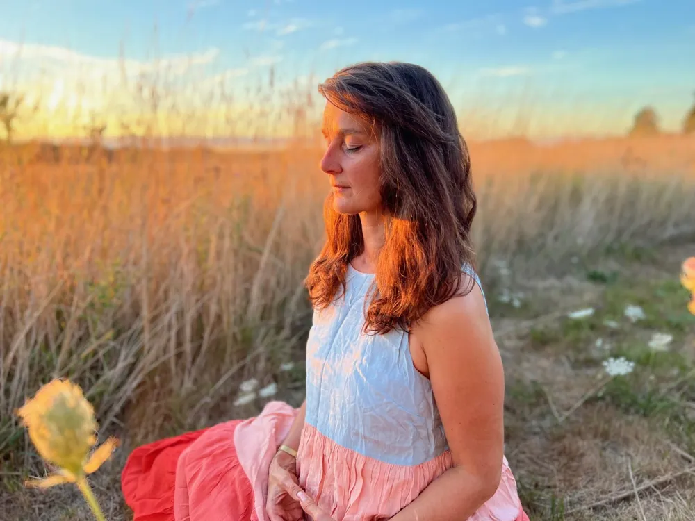 Alexandra Kalinine en méditation au coucher du soleil — présence et écoute au cœur de l’accompagnement