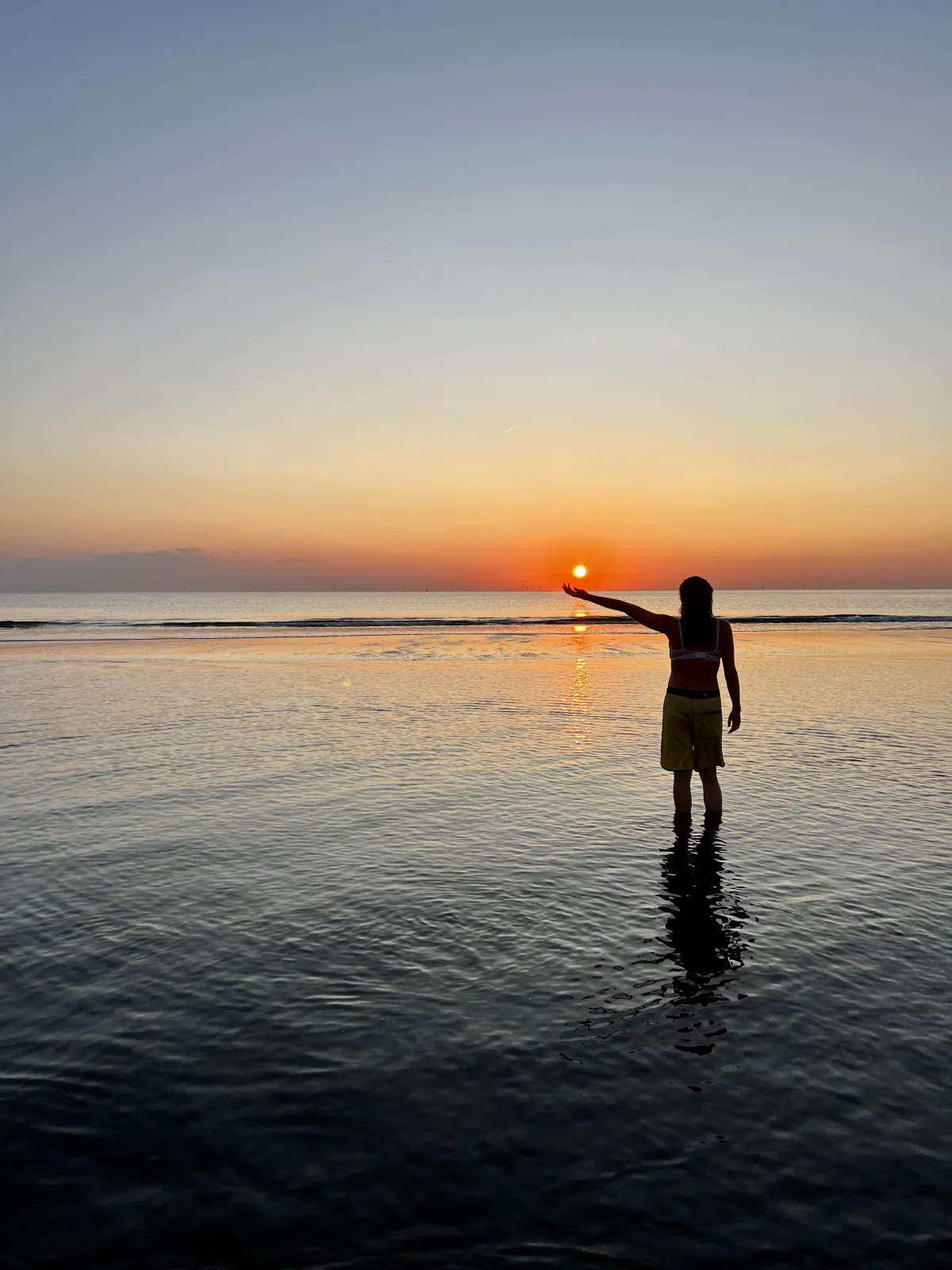 Une personne debout dans la mer au coucher du soleil – accompagnement individuel